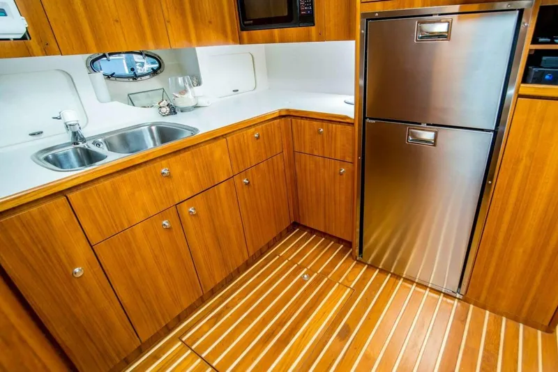 Slide: The Image of Luxurious Tiara 41 Open 2000 yacht kitchen with wood cabinetry and stainless steel appliances. - 4