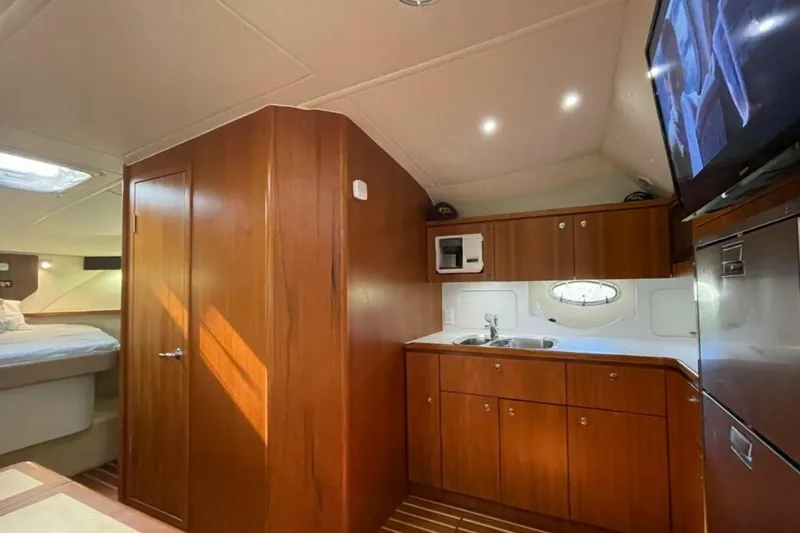 Slide: The Image of Interior of 2000 Tiara 41 Open yacht with wood cabinetry and compact kitchen area. - 6