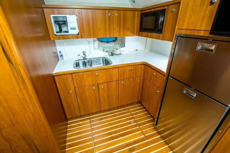 Slide: The Image of Luxurious galley kitchen in 2000 Tiara 41 Open yacht with wood cabinetry and stainless appliances. - 7