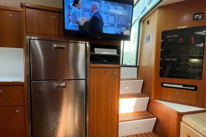 Slide: The Image of Interior of 2000 Tiara 41 Open yacht with TV, fridge, and control panel. - 9