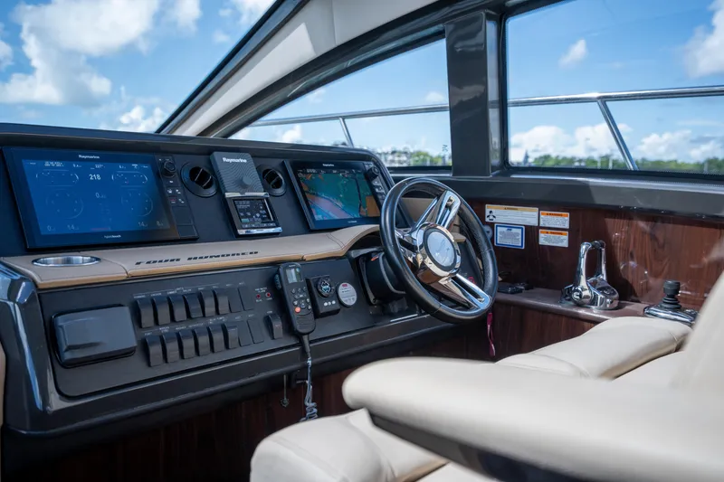 Slide: The Image of Helm of 2016 Sea Ray 400 Sundancer with advanced navigation systems and luxurious seating. - 19