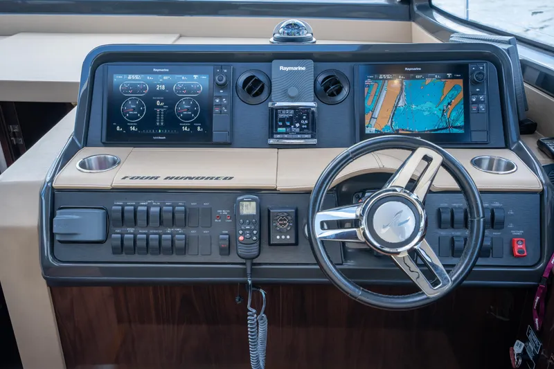 Slide: The Image of Cockpit of 2016 Sea Ray 400 Sundancer with navigation screens and controls. - 21