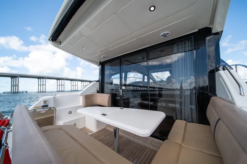 Slide: The Image of 2016 Sea Ray 400 Sundancer yacht interior with seating and table, bridge view. - 23