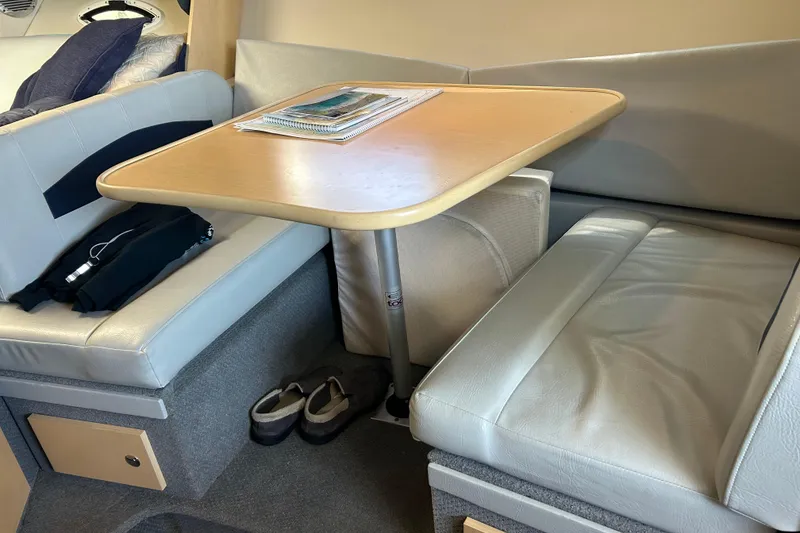 Slide: The Image of Interior of 2011 Bayliner 285 Cruiser with cozy seating and table setup. - 17