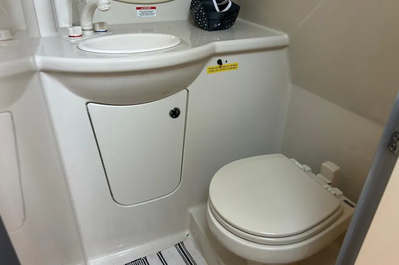 Slide: The Image of 2011 Bayliner 285 Cruiser bathroom with sink and toilet, compact marine design. - 23