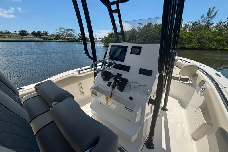 Slide: The Image of 2026 Key West 239 FS boat interior with steering console, on a calm river. - 11