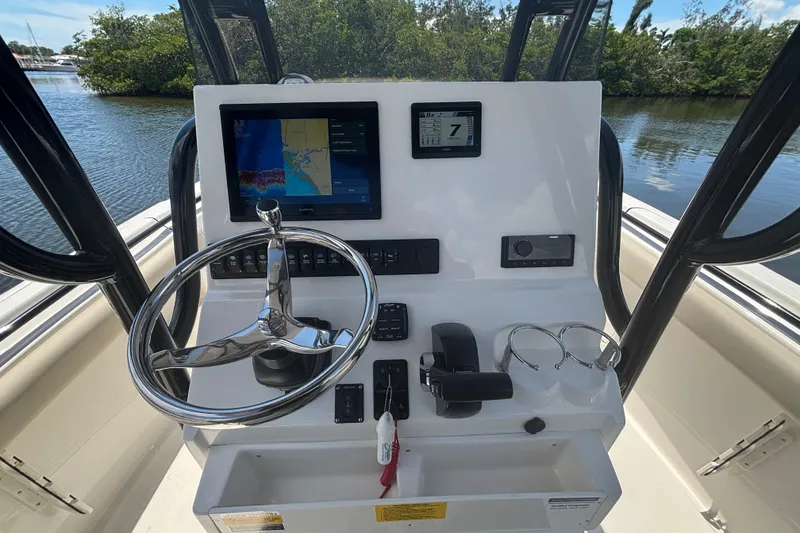 Slide: The Image of 2026 Key West 239 FS boat dashboard with navigation screen and steering wheel. - 12