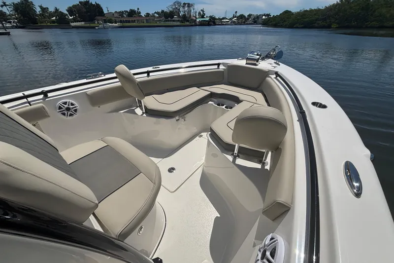 Slide: The Image of 2026 Key West 239 FS boat interior with beige seating on a calm lake. - 13