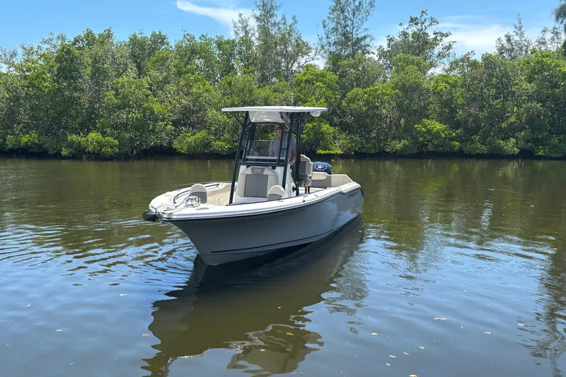 Slide: The Image of 2026 Key West 239 FS boat on calm water, surrounded by lush greenery. - 2