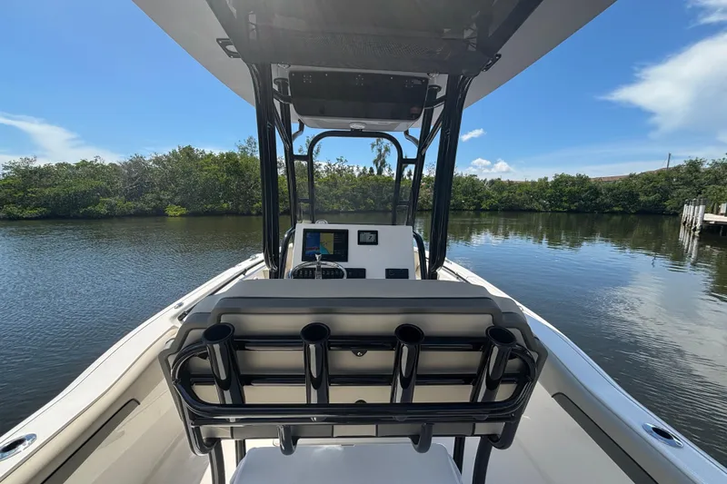 Slide: The Image of 2026 Key West 239 FS boat interior with console, on calm water, surrounded by greenery. - 9