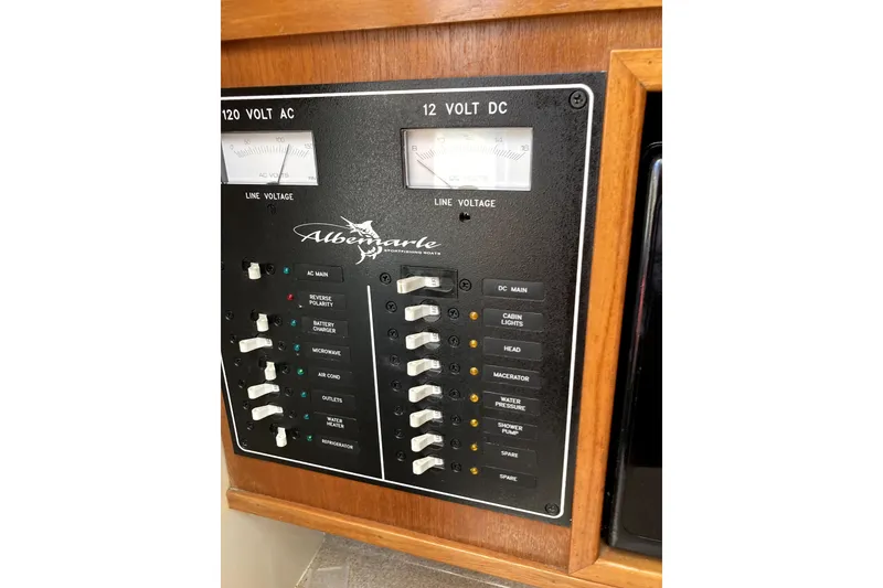 Slide: The Image of Electrical panel of a 2002 Albemarle 28 Express boat, showing AC and DC voltage controls. - 11
