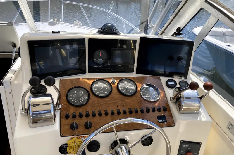 Slide: The Image of Control panel of a 2002 Albemarle 28 Express boat with gauges and navigation screens. - 12