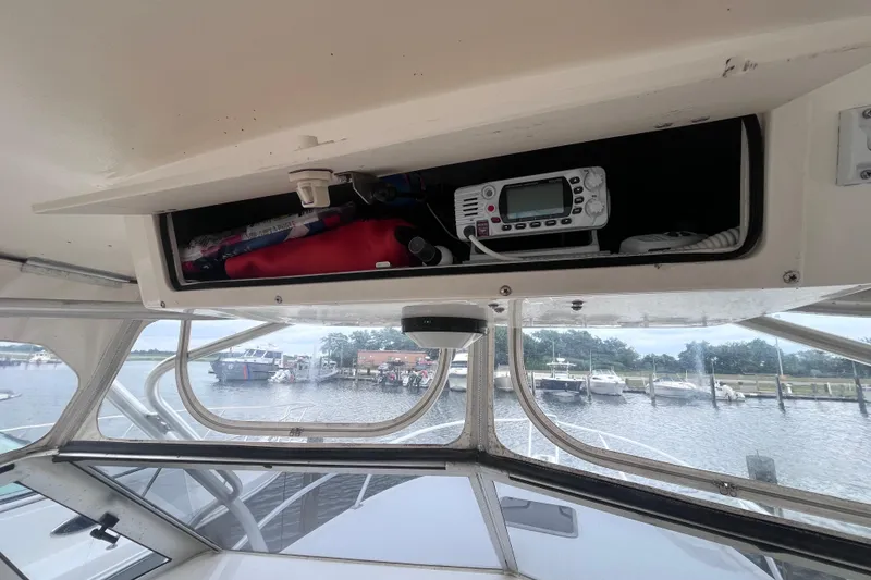 Slide: The Image of 2002 Albemarle 28 Express boat interior with storage compartment and marine radio. - 20