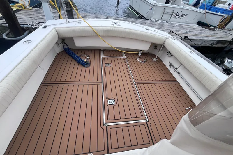 Slide: The Image of 2002 Albemarle 28 Express boat deck with teak flooring and cushioned seating. - 22