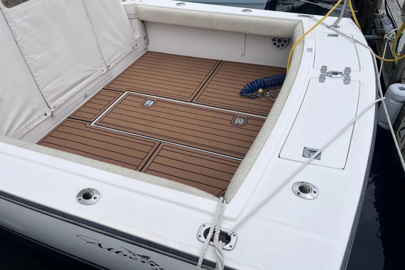 Slide: The Image of 2002 Albemarle 28 Express boat deck with teak flooring and white seating. - 4