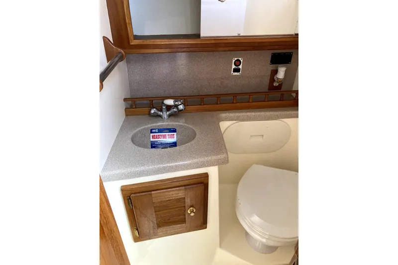 Slide: The Image of 2002 Albemarle 28 Express boat bathroom with sink, mirror, and toilet. - 7