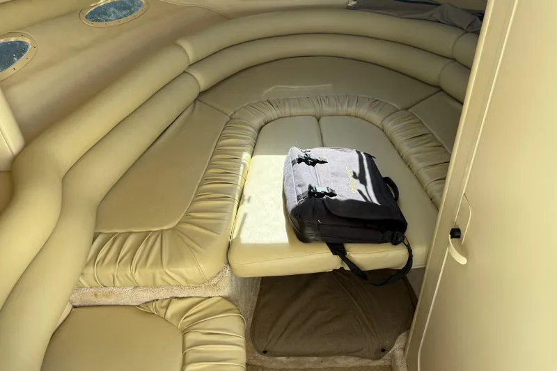 Slide: The Image of Interior cabin of 1998 Sea Ray 280 Sun Sport with beige seating and a black bag. - 4