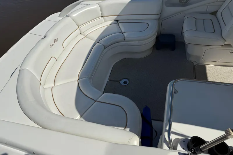 Slide: The Image of 1998 Sea Ray 280 Sun Sport boat interior with white cushioned seating and carpeted floor. - 5