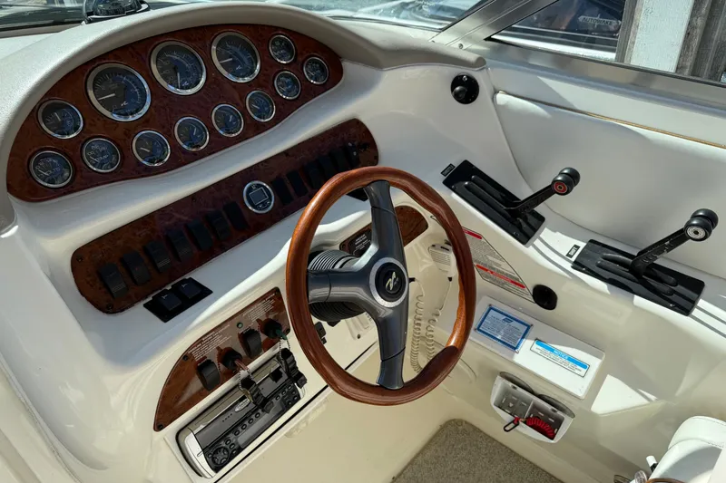 Slide: The Image of Cockpit of 1998 Sea Ray 280 Sun Sport with wood-accented steering and control panel. - 6