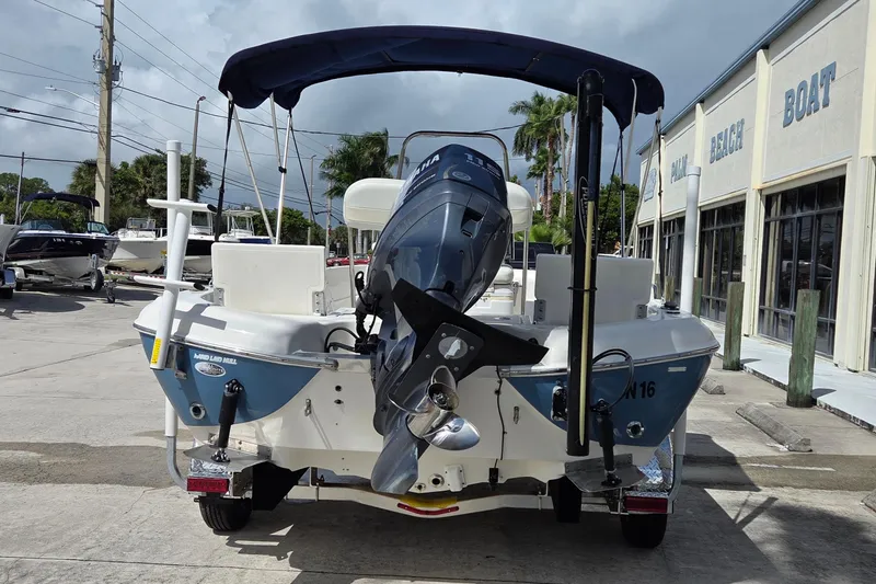 Slide: The Image of 2006 NauticStar 1900 Nautic Bay boat with outboard motor, parked at a marina. - 3