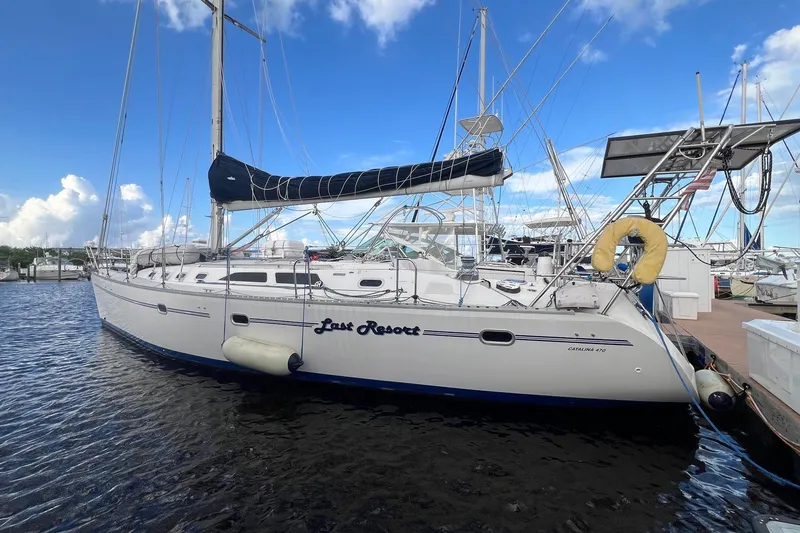 The Image of 1999 Catalina 470 sailboat docked at marina under blue sky. - 0