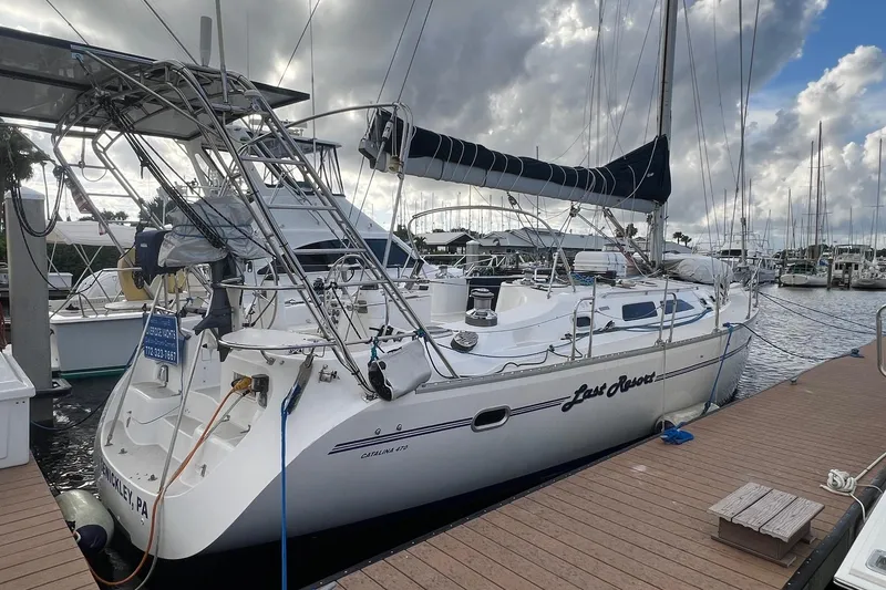 Slide: The Image of 1999 Catalina 470 sailboat docked at marina under cloudy sky. - 2