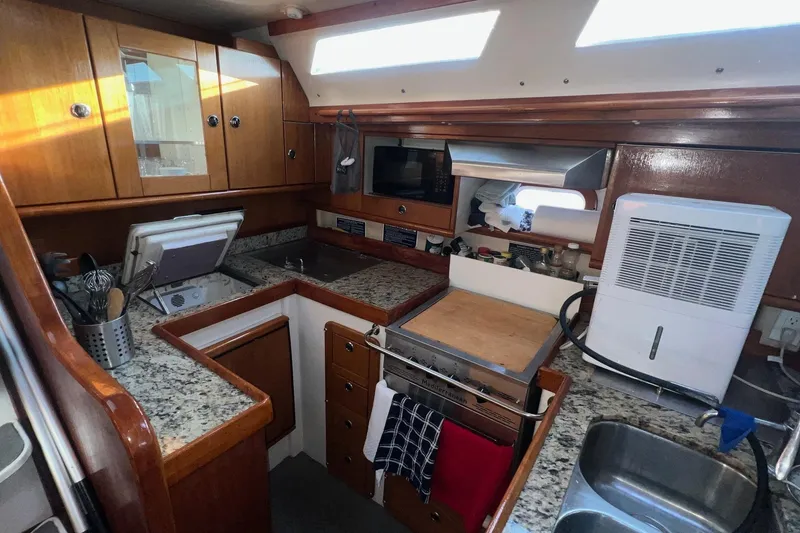 Slide: The Image of Cozy Catalina 470 yacht kitchen with granite countertops and wooden cabinets, 1999 model. - 21