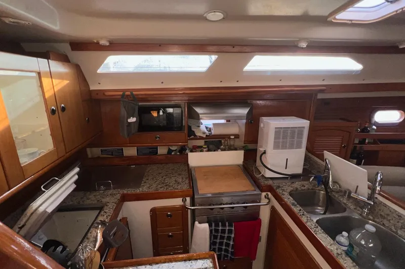 Slide: The Image of Interior of 1999 Catalina 470 yacht kitchen with wooden cabinets and granite countertops. - 22