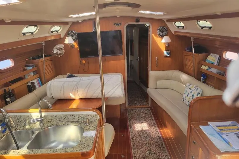 Slide: The Image of Luxurious interior of a 1999 Catalina 470 yacht with cozy seating and modern amenities. - 24