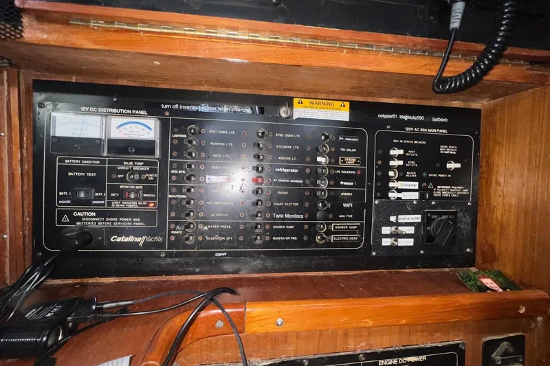 Slide: The Image of Electrical control panel on a 1999 Catalina 470 yacht, featuring various switches and gauges. - 28