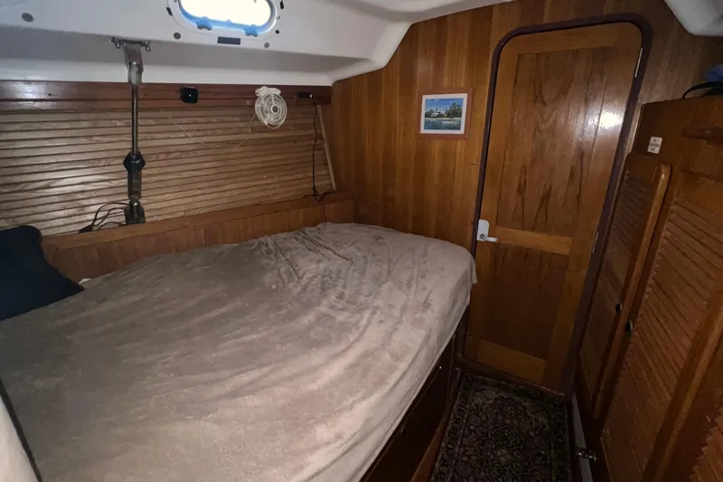 Slide: The Image of Cozy cabin interior of 1999 Catalina 470 sailboat with wooden paneling and bed. - 30