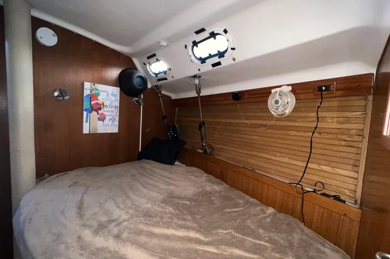 Slide: The Image of Cozy cabin interior of a 1999 Catalina 470 sailboat with bed and nautical decor. - 31