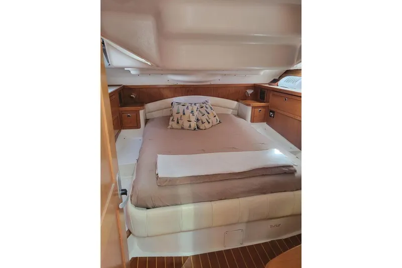 Slide: The Image of Cozy cabin interior of 1999 Catalina 470 sailboat with bed and wooden cabinetry. - 37