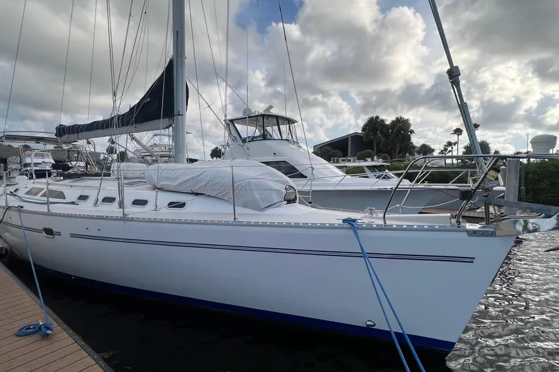 Slide: The Image of 1999 Catalina 470 sailboat docked at marina under cloudy sky. - 4