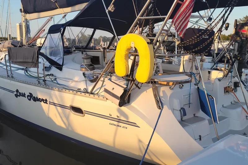 Slide: The Image of Sailboat Catalina 470, 1999 model, docked with yellow life preserver and American flag. - 8