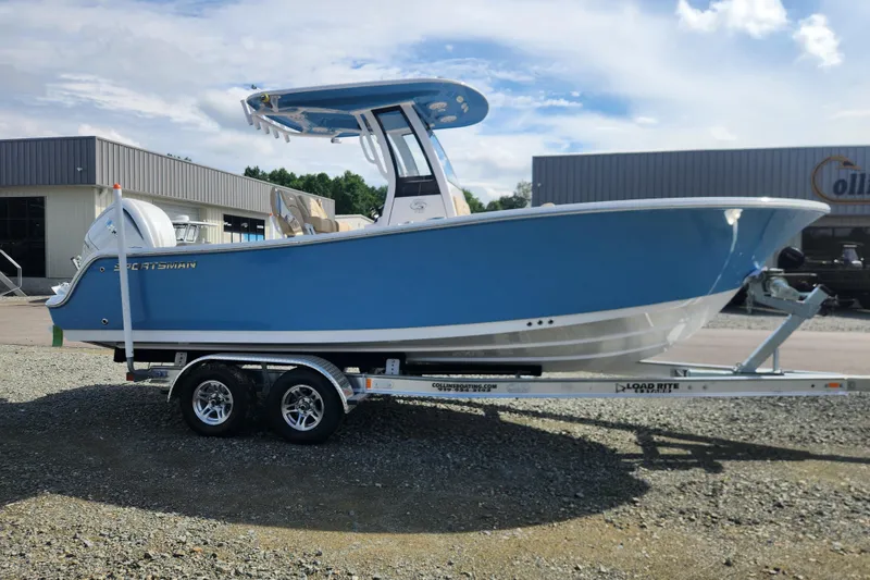 Slide: The Image of 2026 Sportsman Open 232 Center Console boat on trailer, blue hull, parked outdoors. - 0