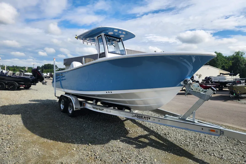 Slide: The Image of 2026 Sportsman Open 232 Center Console boat on trailer, blue hull, outdoor display. - 1