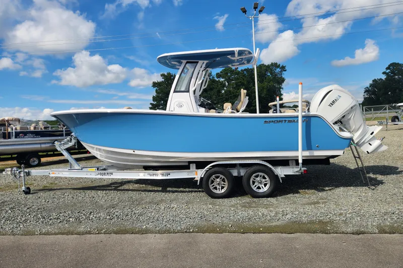 Slide: The Image of 2026 Sportsman Open 232 Center Console boat on trailer, blue hull, clear sky background. - 5