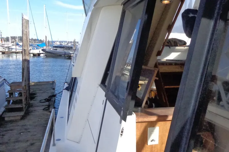 Slide: The Image of 1999 Bayliner 4788 Pilot House Motoryacht docked at marina, side view. - 11