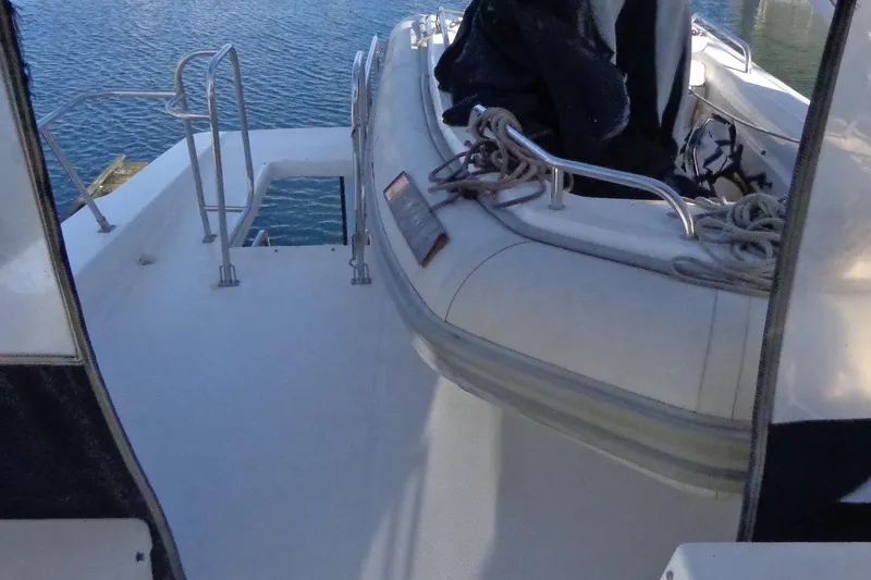 Slide: The Image of 1999 Bayliner 4788 Pilot House Motoryacht deck with inflatable boat and ropes. - 14