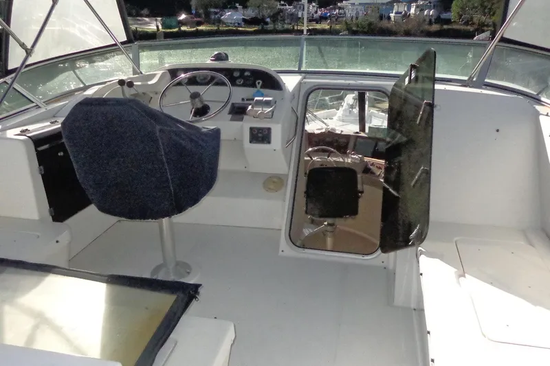 Slide: The Image of 1999 Bayliner 4788 Pilot House Motoryacht helm with steering wheel and navigation controls. - 15