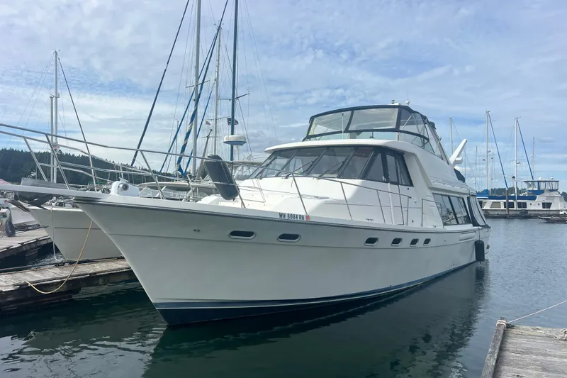 Slide: The Image of 1999 Bayliner 4788 Pilot House Motoryacht docked at marina under blue sky. - 4