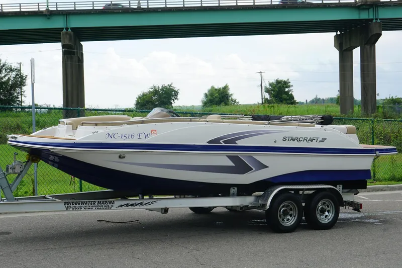 Slide: The Image of 2017 Starcraft Star Step 221 I/O boat on trailer, parked near a bridge. - 10