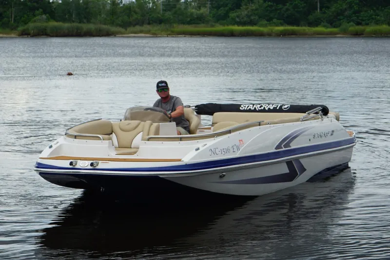 Slide: The Image of 2017 Starcraft Star Step 221 I/O boat on calm water with driver. - 16