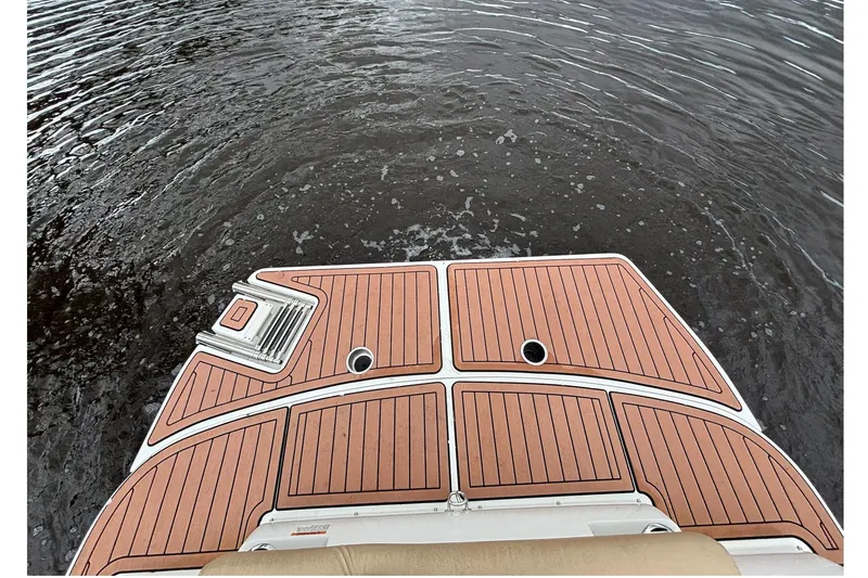 Slide: The Image of 2017 Starcraft Star Step 221 I/O boat deck with wood finish on water. - 22