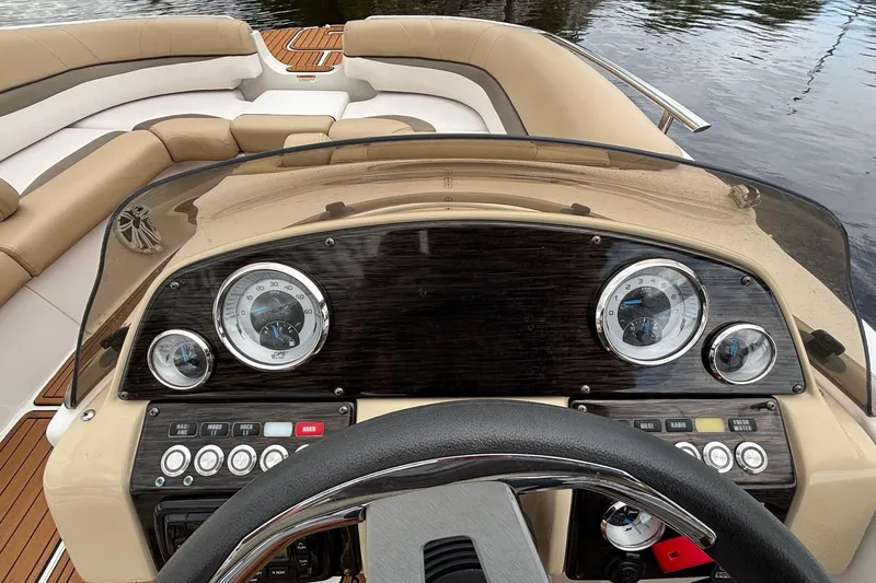 Slide: The Image of 2017 Starcraft Star Step 221 I/O boat dashboard with gauges and controls, overlooking water. - 25