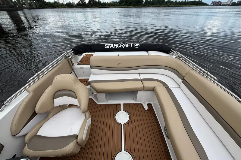 Slide: The Image of 2017 Starcraft Star Step 221 I/O boat interior with tan and white seating on water. - 9