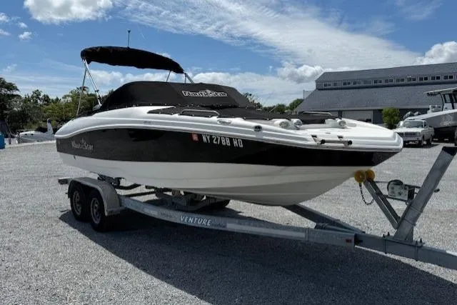 Slide: The Image of 2017 NauticStar 203DC Sport Deck boat on trailer, parked outdoors. - 3