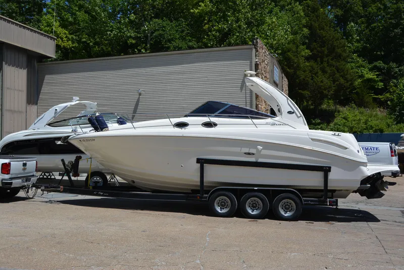 Slide: The Image of 2004 Sea Ray 300 Sundancer boat on trailer, parked outdoors. - 12