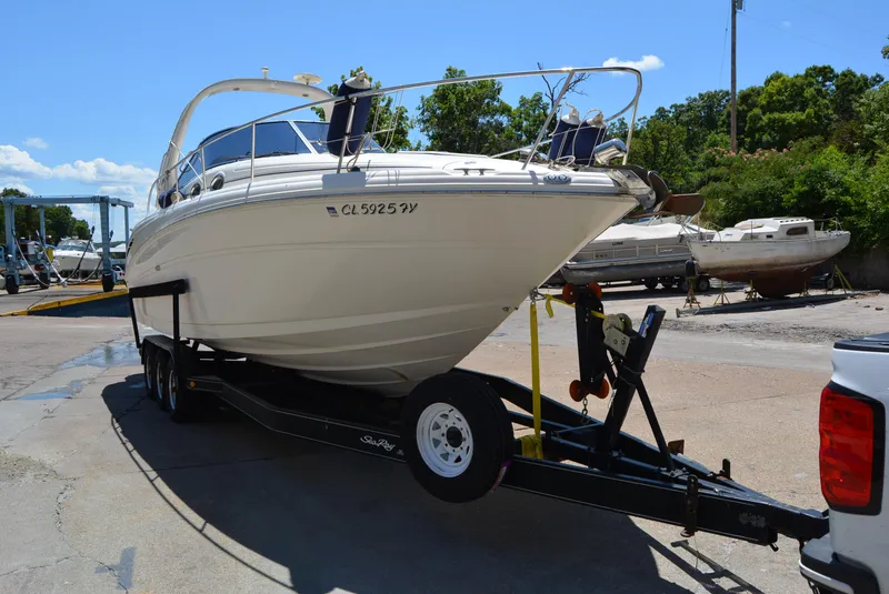 Slide: The Image of 2004 Sea Ray 300 Sundancer boat on trailer in sunny marina setting. - 18